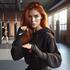 a woman with red hair is posing for a photo in a boxing ring and punching her fist