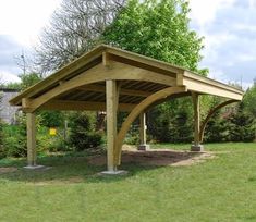 an outdoor covered area in the middle of a yard with trees and bushes around it