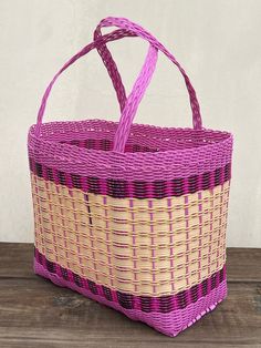 a purple and yellow basket sitting on top of a wooden table