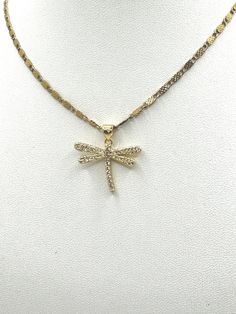 This is an elegant necklace with a delicate gold plated chain link bracelet,  featuring a textured design. The pendant is a dragonfly adorned with micro pave clear cubic zirconia to give it a sparkling appearance.  Pendant size 24mm wide and 20mm long. The dragonfly is a symbol often associated with transformation and adaptability, making this piece not just a fashion statement but potentially also a personal emblem or a meaningful gift. The contrast between the simple chain and the intricate dragonfly creates a balanced and sophisticated look. Elegant Gold Dragonfly Jewelry, Gold Dragonfly Necklace For Gift, Delicate Yellow Gold Butterfly Pendant Necklace, Elegant Gold Dragonfly Necklace, Butterfly Wing Pendant, Elegant Gold Winged Necklace, Dragonfly Pendant, Elegant Necklaces, Micro Pave