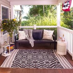 a porch with a black and white rug on it