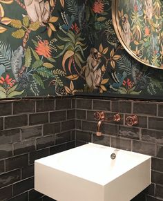 the bathroom is decorated with colorful wallpapers and an animal themed mirror above the sink