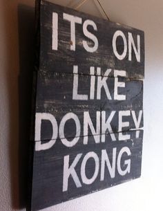 a wooden sign hanging on the wall that says it's on like donkey kong