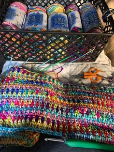 a basket filled with yarn and scissors on top of a table