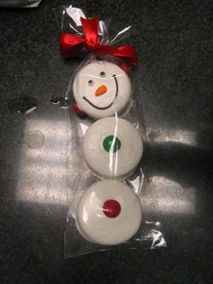 three snowmen are wrapped in plastic and have red bows on their heads, one is white