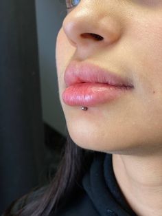 a close up of a woman's face with her nose piercings in front of her