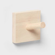 a wooden block with a handle on it and a round knob in the middle that is mounted to the wall