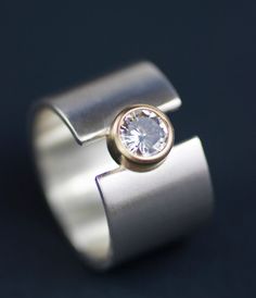 a silver ring with a white diamond in the center