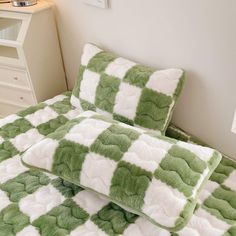 a green and white checkered comforter on a bed