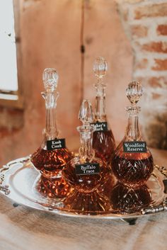 three bottles of liquor sitting on top of a silver tray