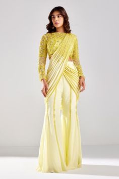 Pastel yellow pre-draped pant saree with beads, cutdana embroidery. Paired with a blouse with all over cutdana, beads, floral embroidery. Components: 2 Pattern: Embroidery Type Of Work: Cutdana, Sequins, Floral Neckline: Boat Neck Sleeve Type: Full Sleeves Fabric: Satin Lycra, Tulle and Shantoon Color: Yellow Other Details:  Crystal stone laced blouse Note: All the jewellery worn by the model is not for sale Occasion: Sangeet - Aza Fashions Pant Saree Style, Saree With Pants, Sarees Ideas, Shadi Dress, Cutdana Embroidery, Desi Attire, Saree Jackets, Long Blouse Designs