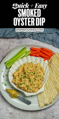 a plate with crackers, celery, carrots and dip on it