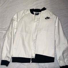 Never Worn. Good Condition. Breathable Jacket. No Tears. Good Zipper. No Discoloration. Nike Urban Style White Windbreaker, Nike White Outdoor Outerwear, White Track Jacket With Pockets For Fall, Urban White Nike Track Jacket, Urban Nike White Track Jacket, Nike Urban White Track Jacket, White Windbreaker For Workwear In Winter, White Casual Windbreaker For Fall, White Winter Windbreaker For Work