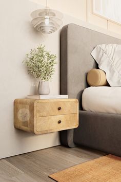 a nightstand with a plant on top of it next to a bed in a bedroom