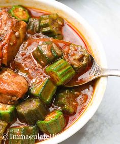 a bowl filled with meat and vegetables covered in sauce