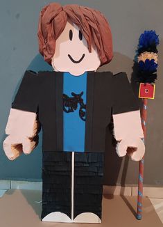 a paper doll made to look like he is holding a broom