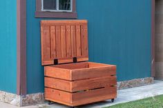 a wooden box sitting in front of a blue building