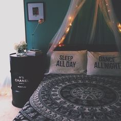 a bed with two pillows on top of it next to a night stand and lamp