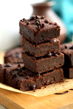 a stack of brownies sitting on top of a wooden cutting board