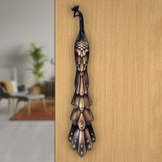 a metal peacock is hanging on the side of a door