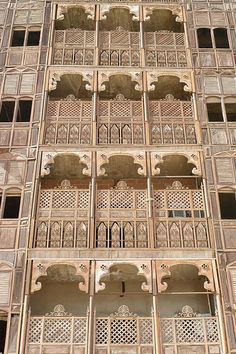 an intricately carved wooden building with windows and balconies on the side of it