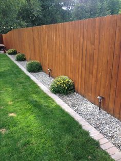 a wooden fence next to a grassy yard