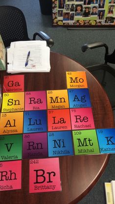 a wooden table topped with lots of different colored cards next to a book on top of it