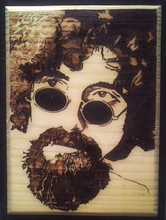 a man's face with large round glasses and beard is made out of wood