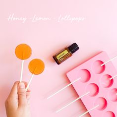 a person holding lollipops on top of a pink tray