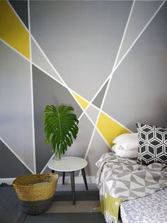 a room with a bed, table and potted plant on the floor next to it