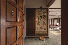 an open door leading to a hallway with a painting on the wall and wooden doors