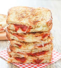 three slices of toasted cheese and tomato sauce sandwich stacked on top of each other