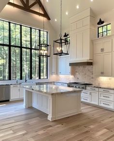 a large kitchen with white cabinets and wood floors