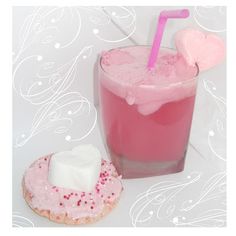 a pink drink next to a donut on a table