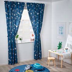 a child's room with blue curtains and toys