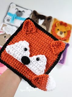 someone is holding up a crocheted square with different animals on it, including a fox and bear