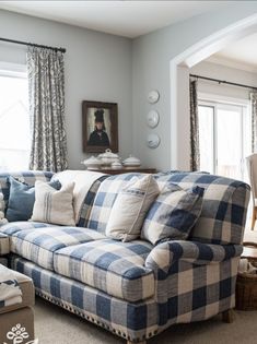 a blue and white checkered couch sitting in a living room next to a window