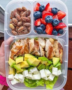 a plastic container filled with different types of fruits and veggies next to nuts