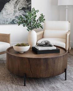 a coffee table with a bowl on it in front of a couch and two chairs