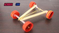 a toy car made out of wooden sticks and plastic wheels on top of a table