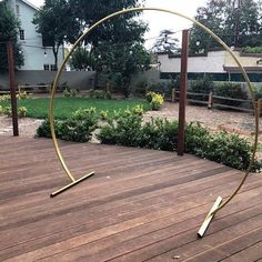 a circular metal object sitting on top of a wooden deck next to a garden area