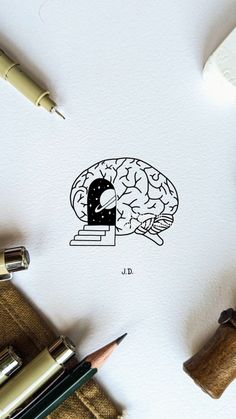 an ink drawing of a brain on top of a piece of paper next to some pencils