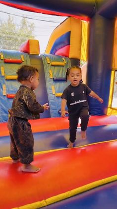 two young children playing on an inflatable bounce house