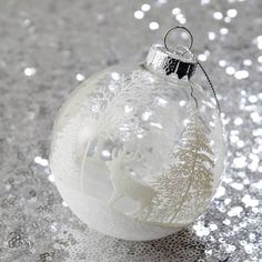 a glass ornament with snowflakes and trees on it