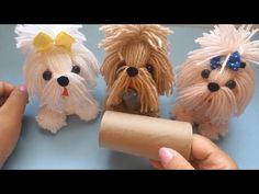 three small dogs made out of toilet paper are being held by someone's hand