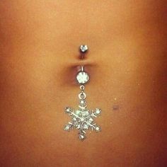 a woman's belly with a snowflake on the side and an upside down piercing