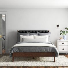 a bedroom with white walls and wooden floors