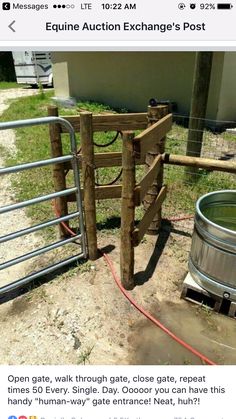 a wooden gate is next to a metal barrel