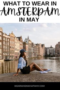 a woman sitting on the edge of a river with text overlay that reads what to wear in amsterdam in may