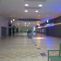 an empty lobby with green chairs and tiled floor